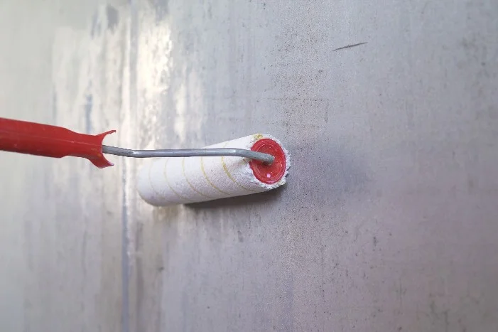 Farbroller grundiert Betonwand